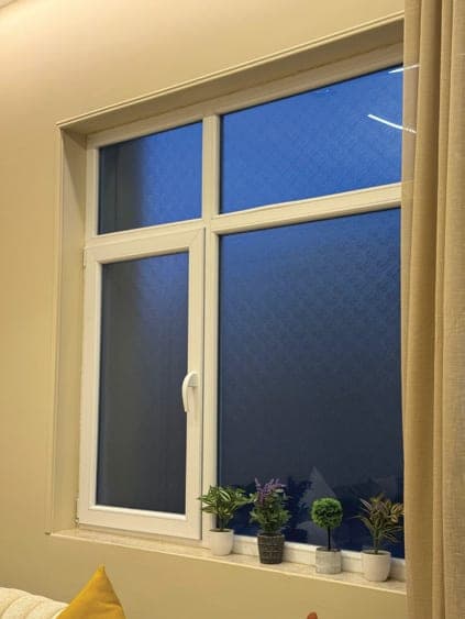 نافذة UPVC بيضاء بزجاج عاكس وأصص نباتات على حافتها
